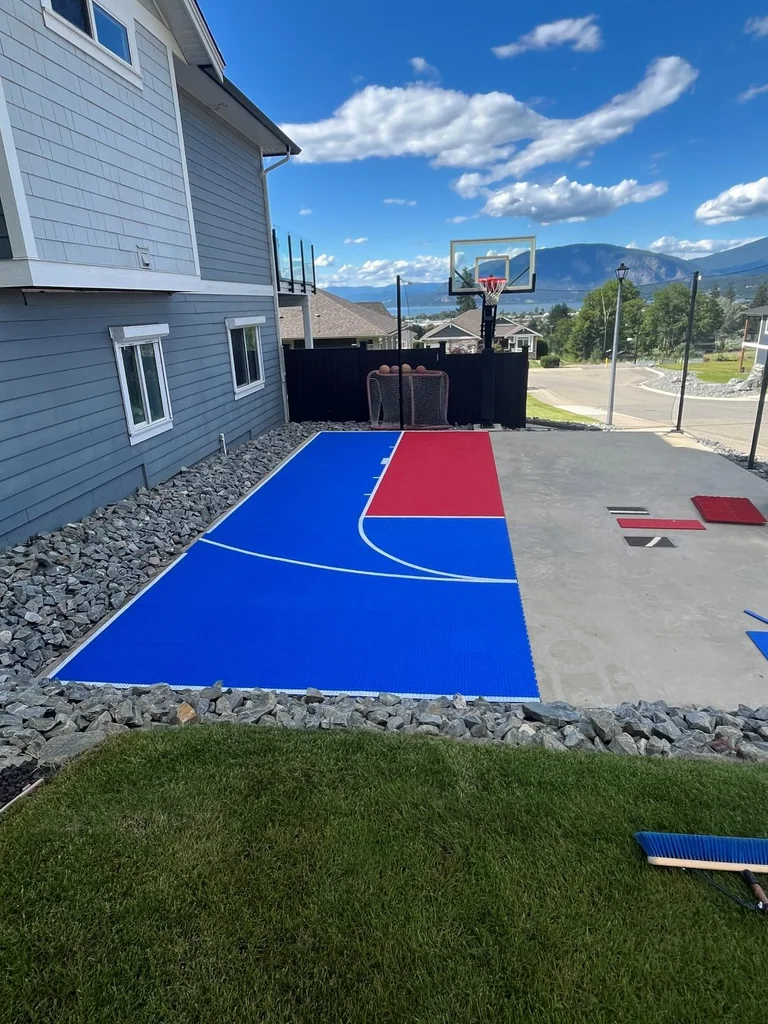 Blue and red court tiles partly installed on the same pad