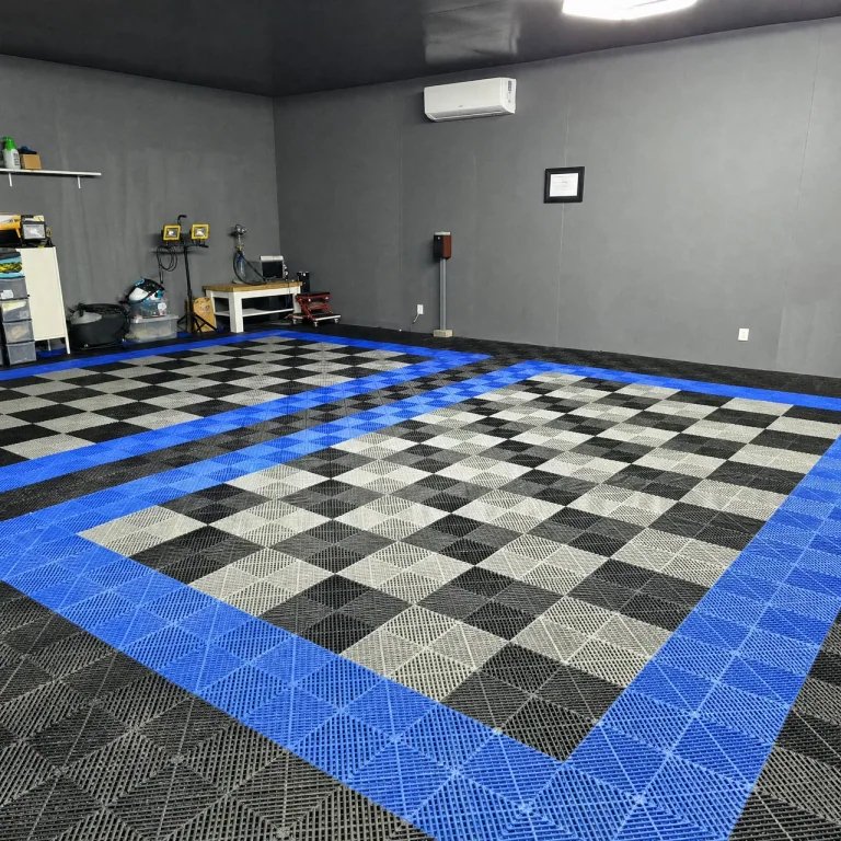 Blue borders around grey and black interlocking garage tiles